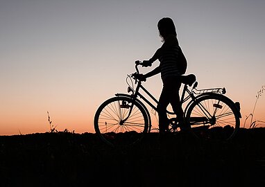 meisje op fiets in de schemeravond